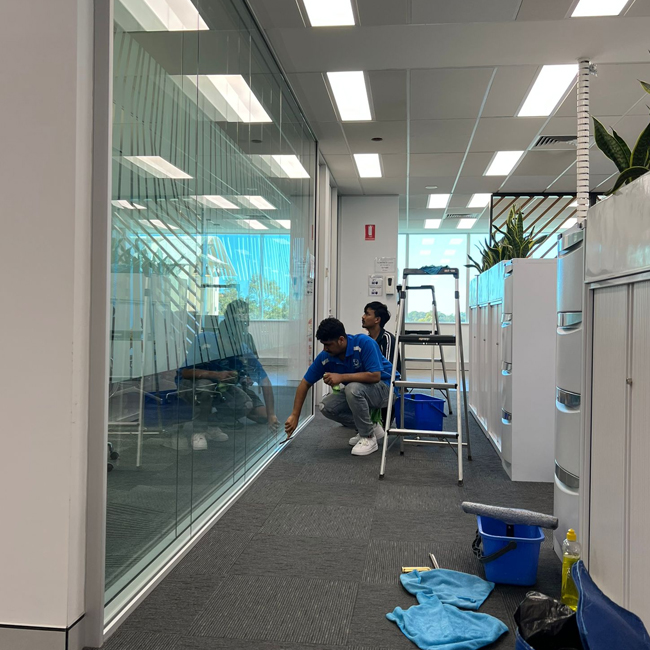 Cleaners cleaning the windows and glass for a commercial office